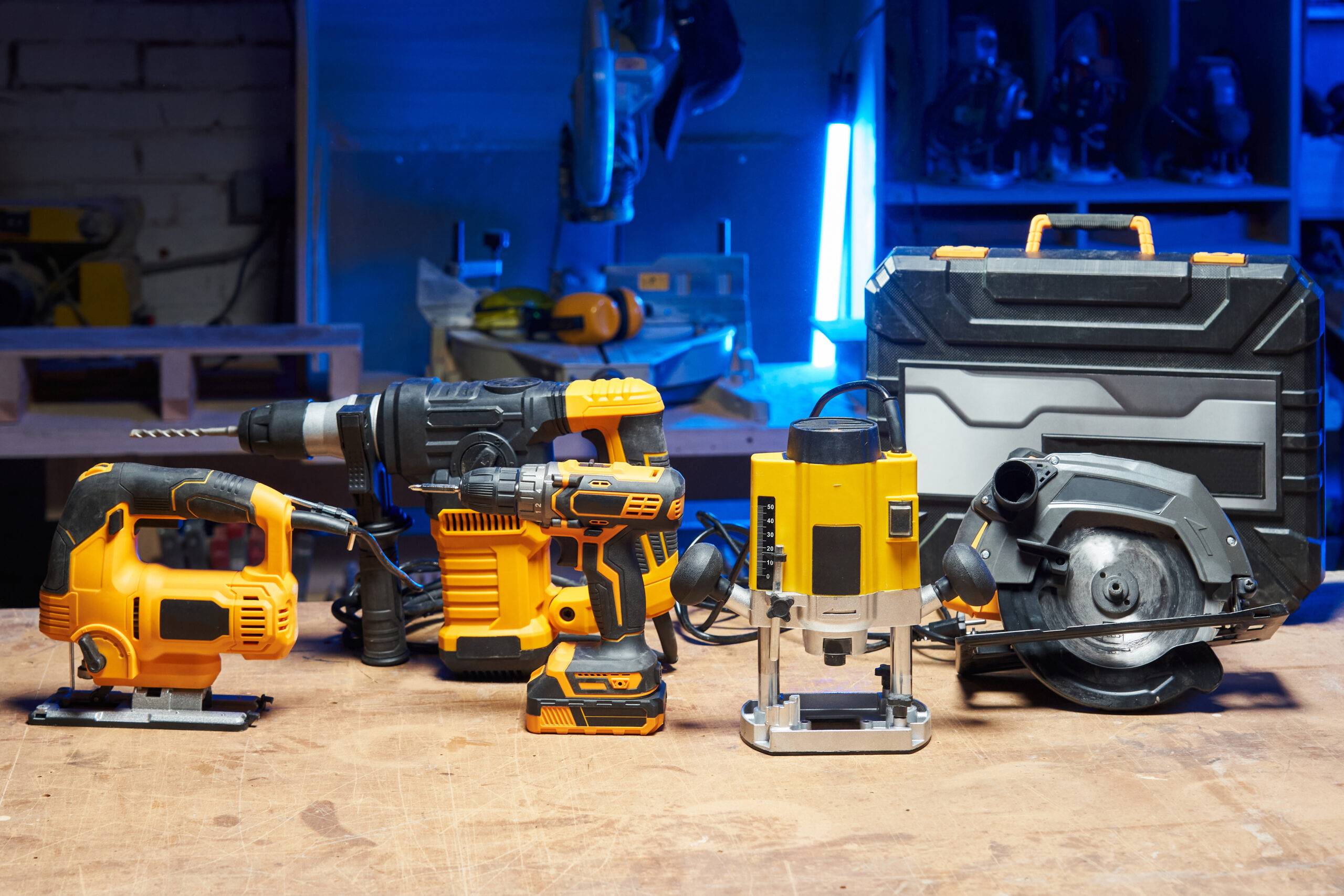 A set of tools and electrical devices is on the table. circular saw, screwdriver, perforator, drill, jigsaw, router in a carpentry workshop. High quality photo