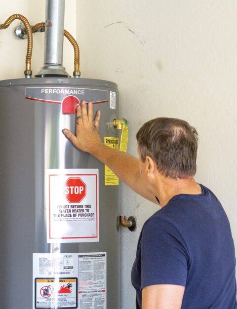 A man inspecting a home water heater.