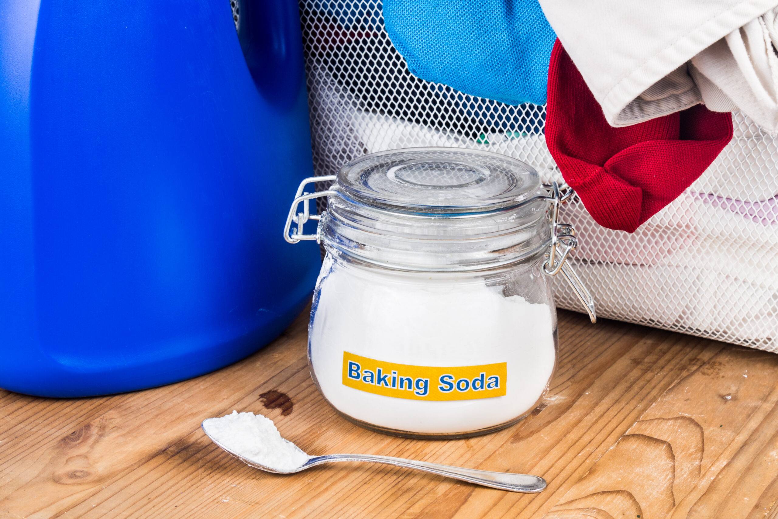 Baking soda with detergent and pile of dirty laundry