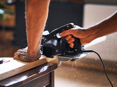 A person using a circular handsaw.