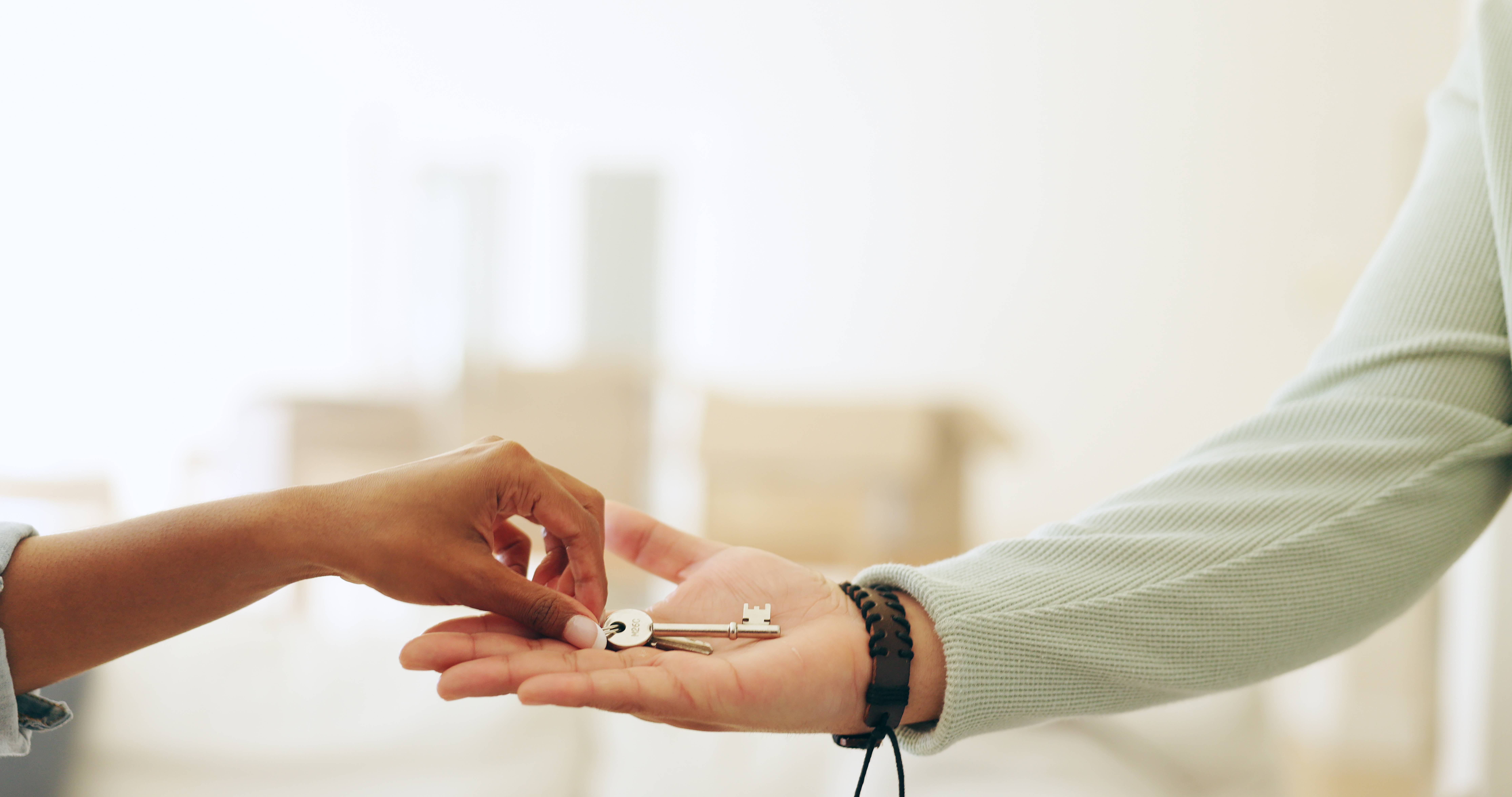 Hands, moving and key by handing over in new home by realtor to owner in sale of property.