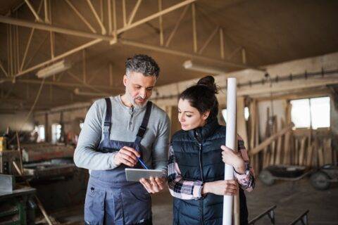 Two contractors overlooking plans on a tablet.