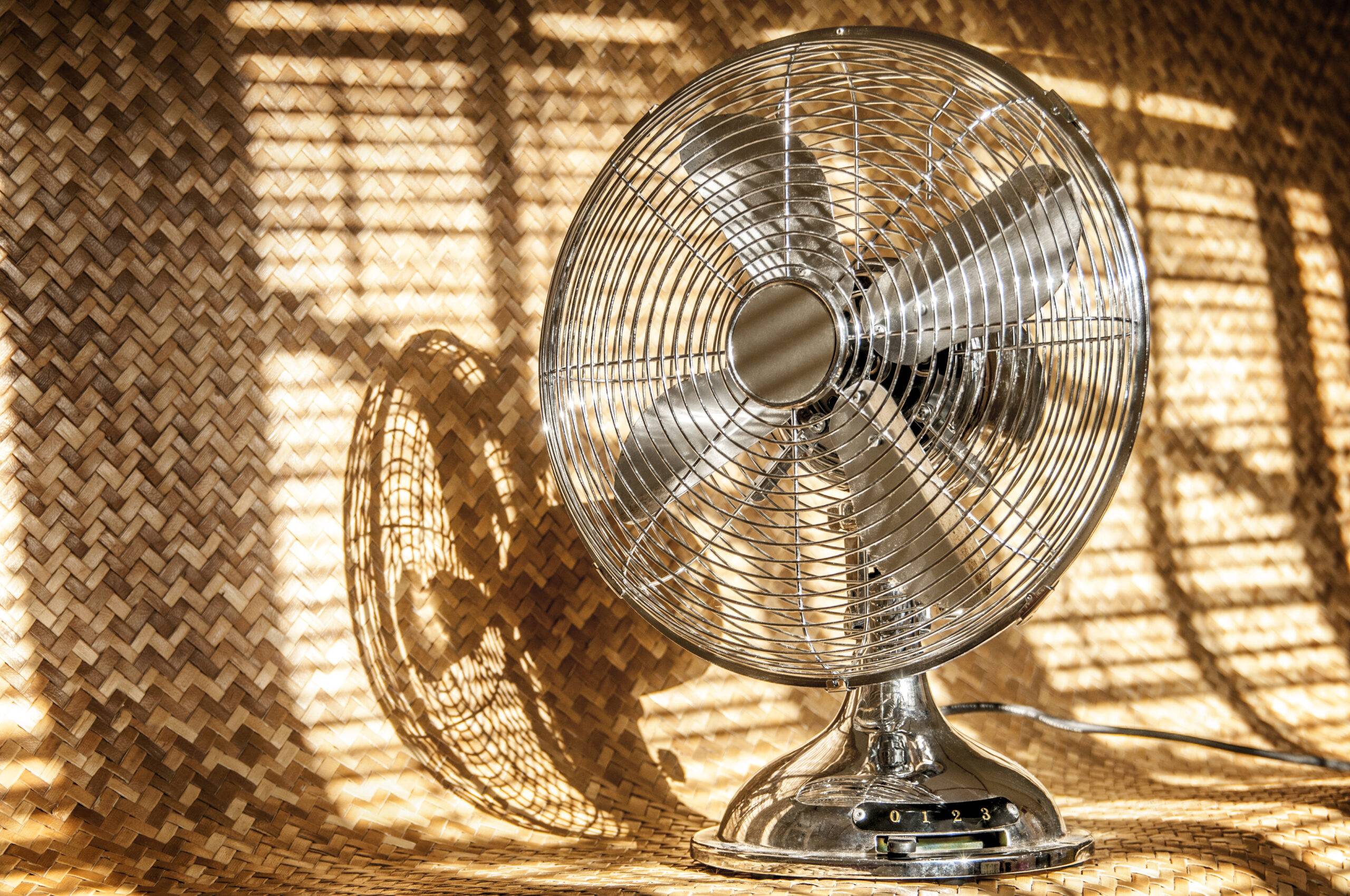 Retro metal fan against rattan background