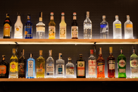 Floating shelf holding liquor bottles.