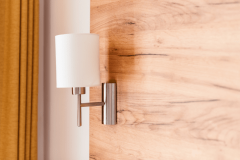 Sconce light on wooden wall.