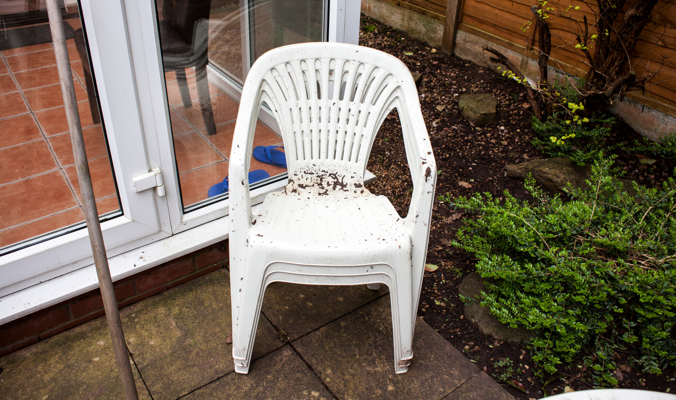 A stack of dirty white plastic chairs.