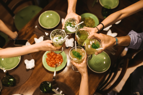 Friends having drinks cheering glasses together.